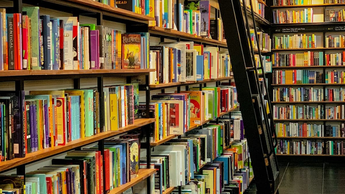 A colorful bookstore with a moving ladder.