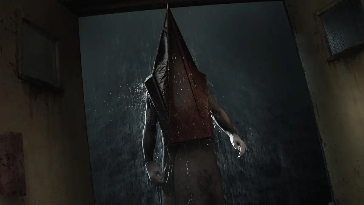 Silent Hill 2: Pyramid Head stands at an open door as heavy rain falls in the background.