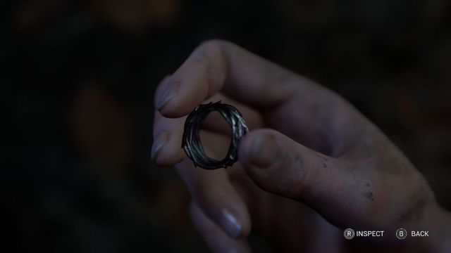 Madi holding the bloodied ring artifact.