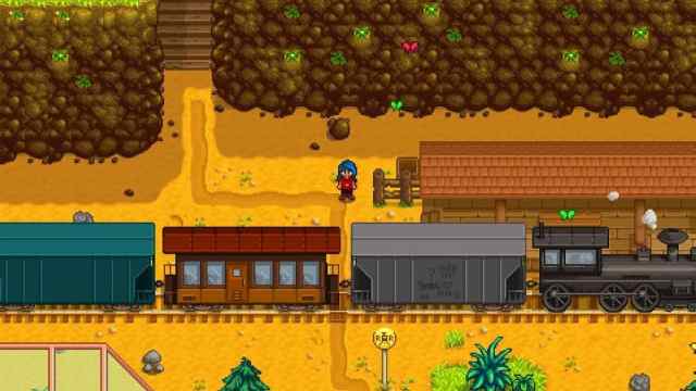 Stardew Valley: a character stand by the train station as a steam train trundles through.