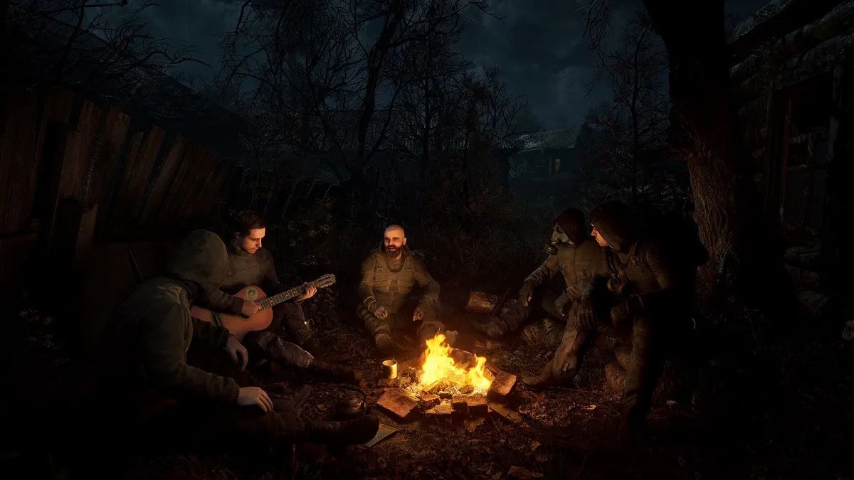 STALKER 2: soldiers sit around a campfire, the only thing that lights them against the night sky.