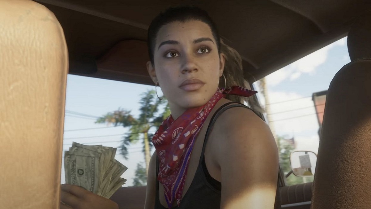 GTA 6: a woman looks behind her as she rides in the front of a car.