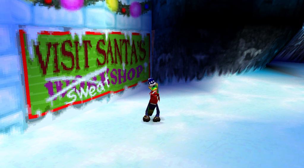 Gex, a green gecko wearing a blue winter hat and red snow jacket, strikes a pose in front of a green sign that says "Visit Santa's workshop." The "work" in workshop has been crossed out and replaced with "sweat."