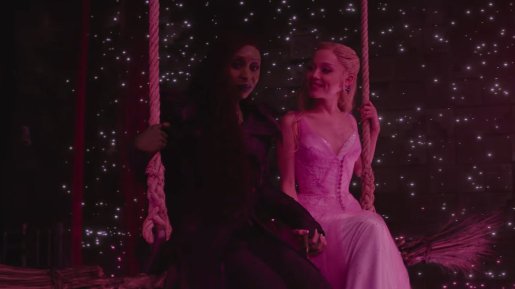 Elphaba and Glinda on a swing in a pink starlit room in wicked for good