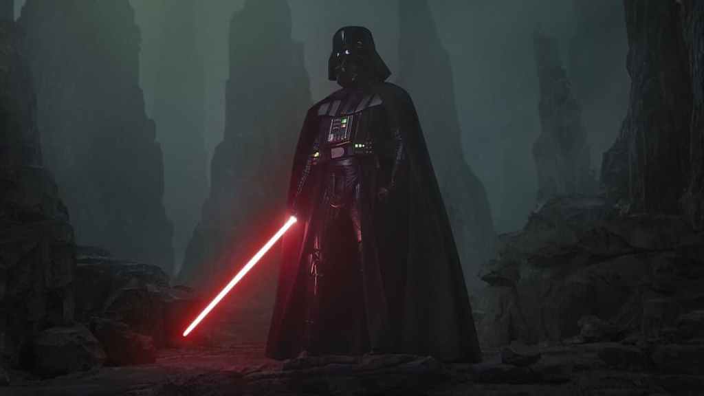 Darth Vader standing in a dark area with his red lightsaber gleaming. 