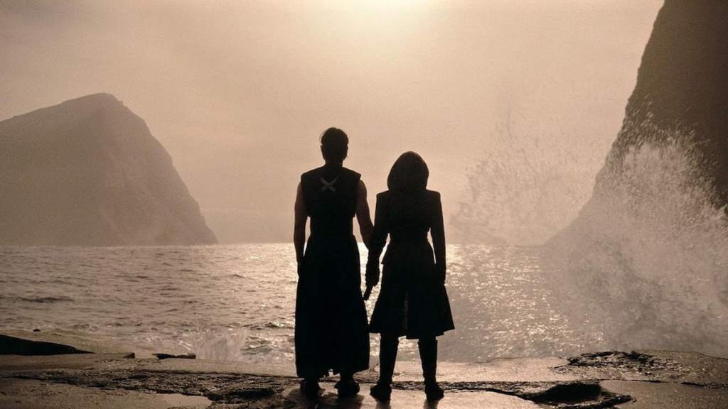 Qimir and Osha holding hands standing on a beach in The Acolyte