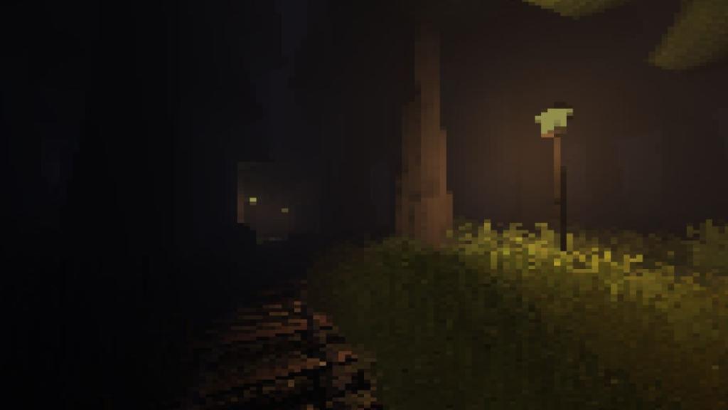 A lit lamppost in the middle of a dark forest, with the train tracks trailing north next to it