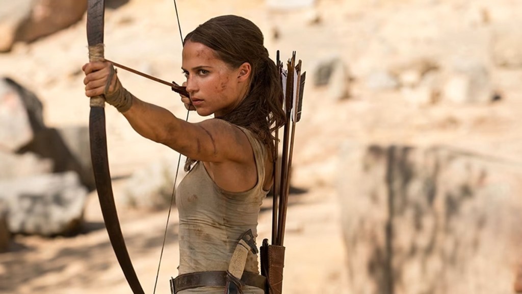 Alicia Vikander as Lara Croft wielding a bow and arrow